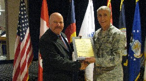 Col. Platt (r) presents Ed Flanagan, chief executive officer, Manitou Motion Picture Company, with a corporate membership certificate in January.